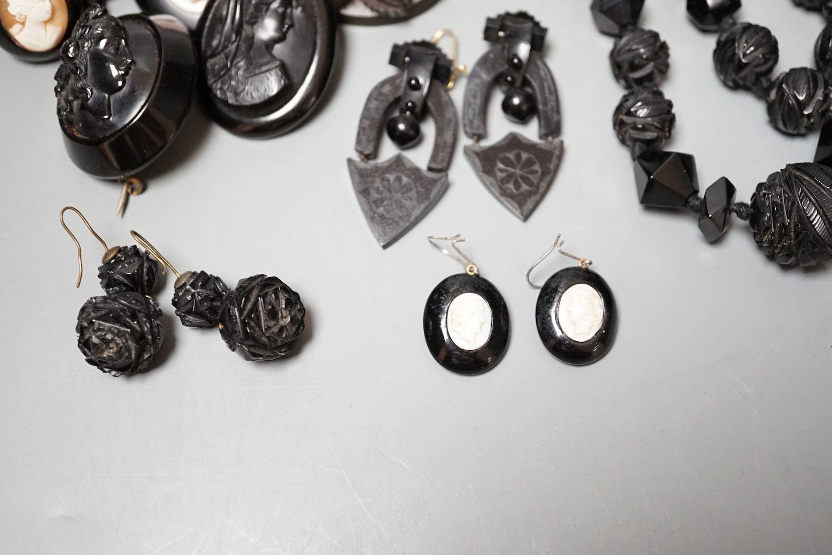 A collection of assorted jet jewellery, some with cameo, including two necklaces, five brooches, a bracelet and three pairs of earrings.